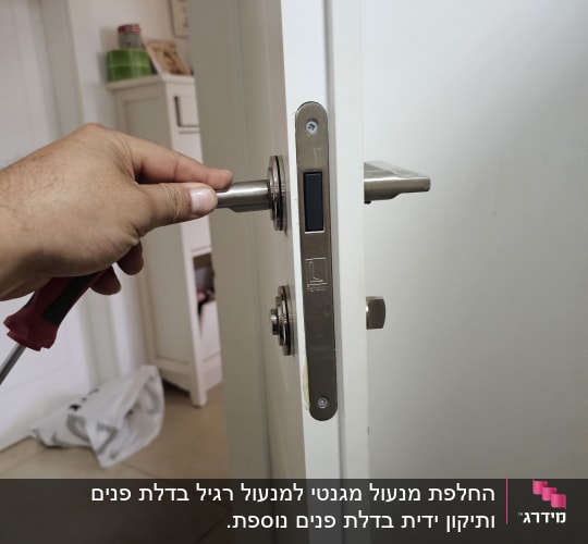 יד מחזיקה מברג ליד מנעול דלת